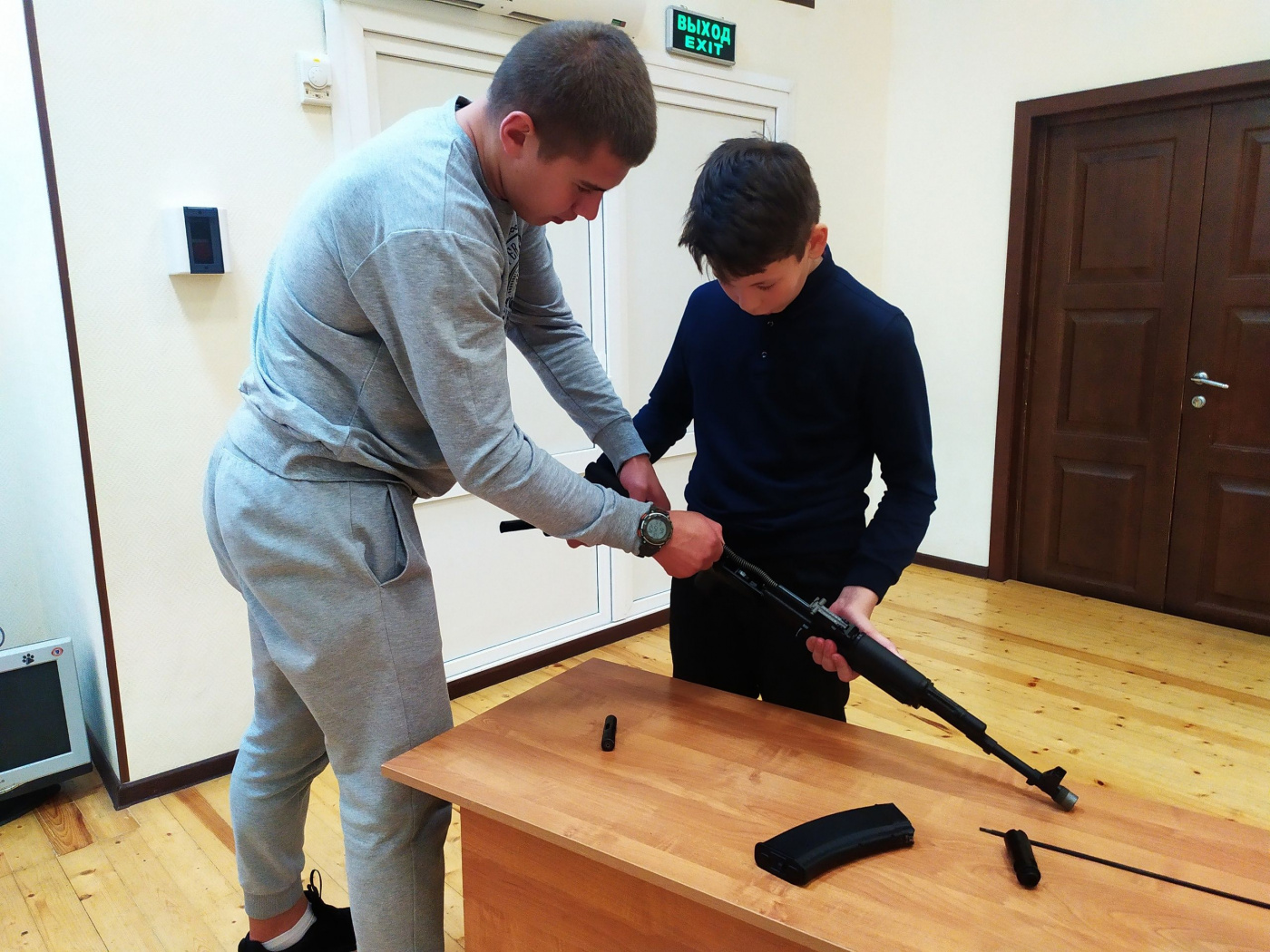 Педагог дополнительного образования, мастер спорта Артем Ильин учит юнармеца сборке автомата Калашникова.jpg