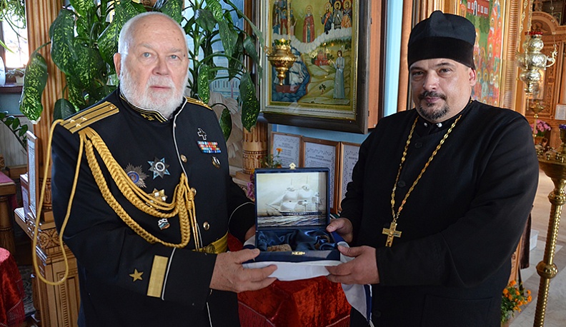 Николай Черкашин передает настоятелю храма отцу Геннадию фрагмент фрегата Паллада.JPG