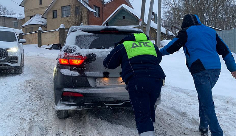 Калужские автоинспекторы выталкивали застрявшие на заснеженном подъеме машины